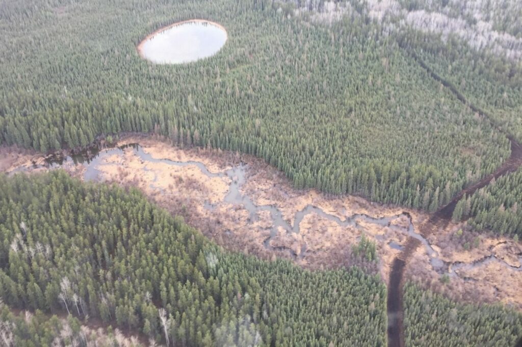 Aerial view of a small circular lake and river